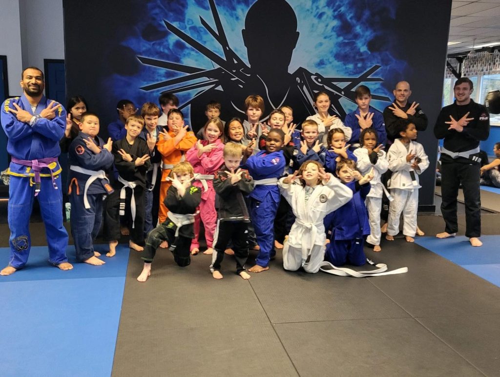 Tiny Titans Jiu Jitsu class posing for photo with instructors