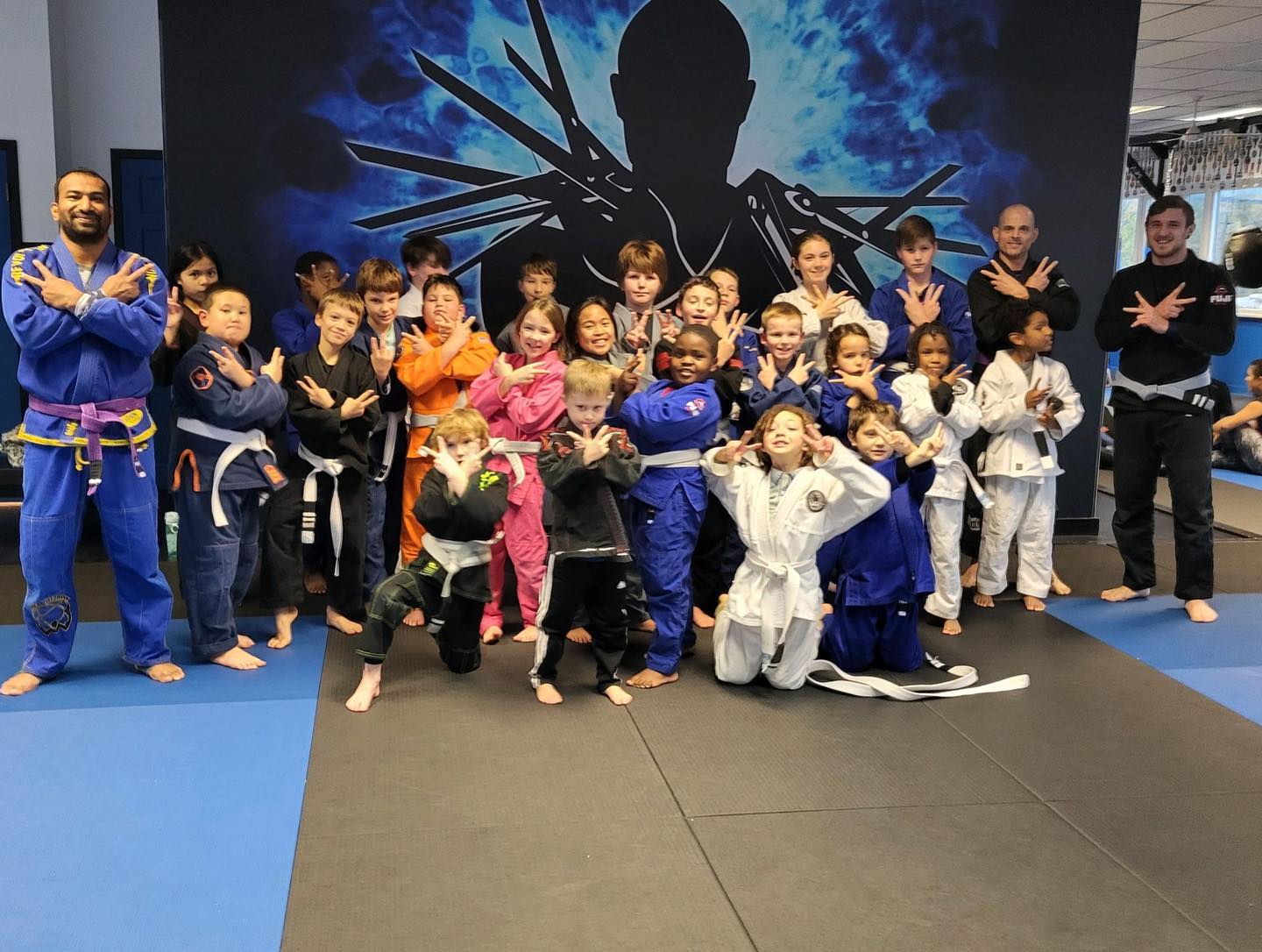 Tiny Titans Jiu Jitsu class posing for photo with instructors